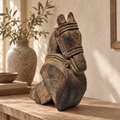 Antique carved wooden horse displayed on a tabletop beside a vase. hoWme