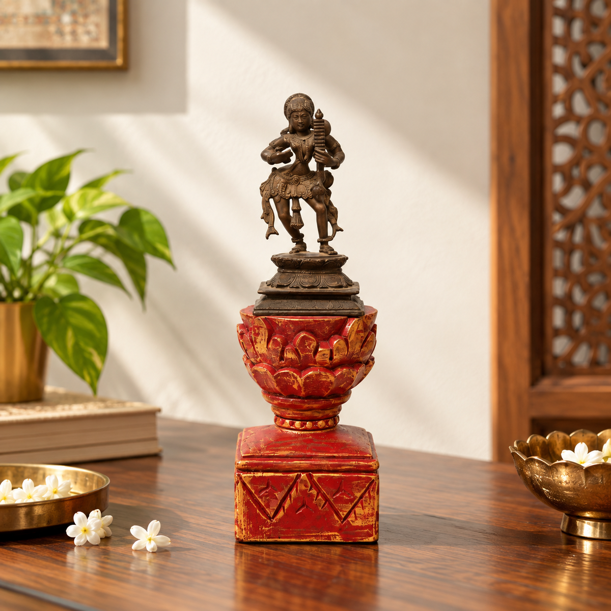 Brass dancing artefact on a red and gold wooden pedestal, tabletop styling. hoWme