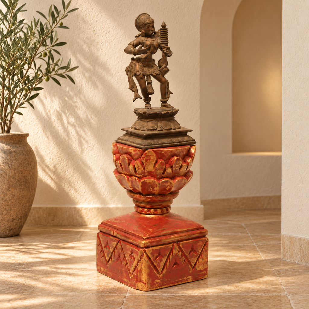 Brass dancing artefact on a red and gold wooden pedestal, styled in a home interior. hoWme