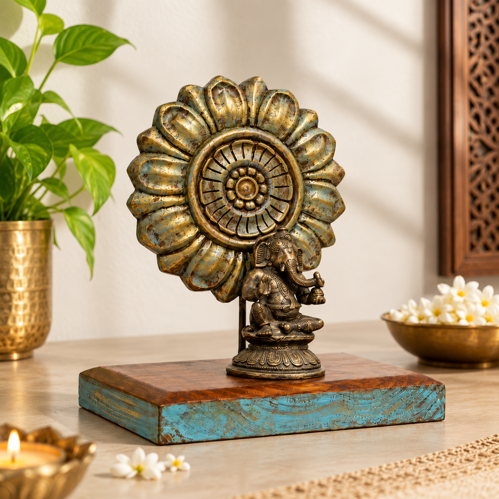 Brass Ganesha with sunburst on a wooden base in a tabletop setting. hoWme