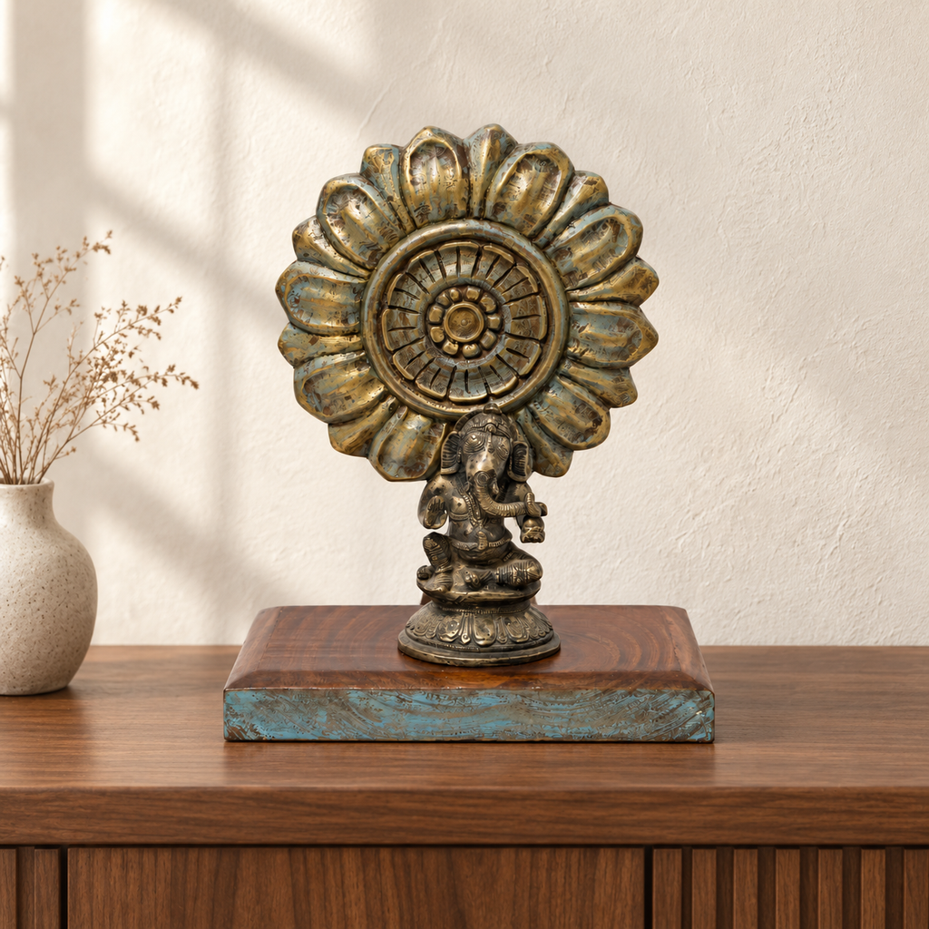Brass Ganesha and carved sunburst on a wooden base, styled on a console. hoWme
