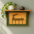 Deer motif key holder shelf on a muted green wall with hanging plant. hoWme