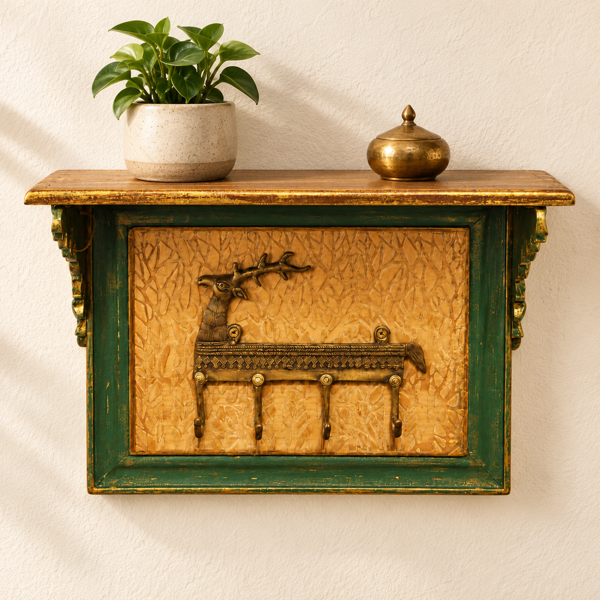 Green and gold key holder wall shelf with plant and brass decor. hoWme