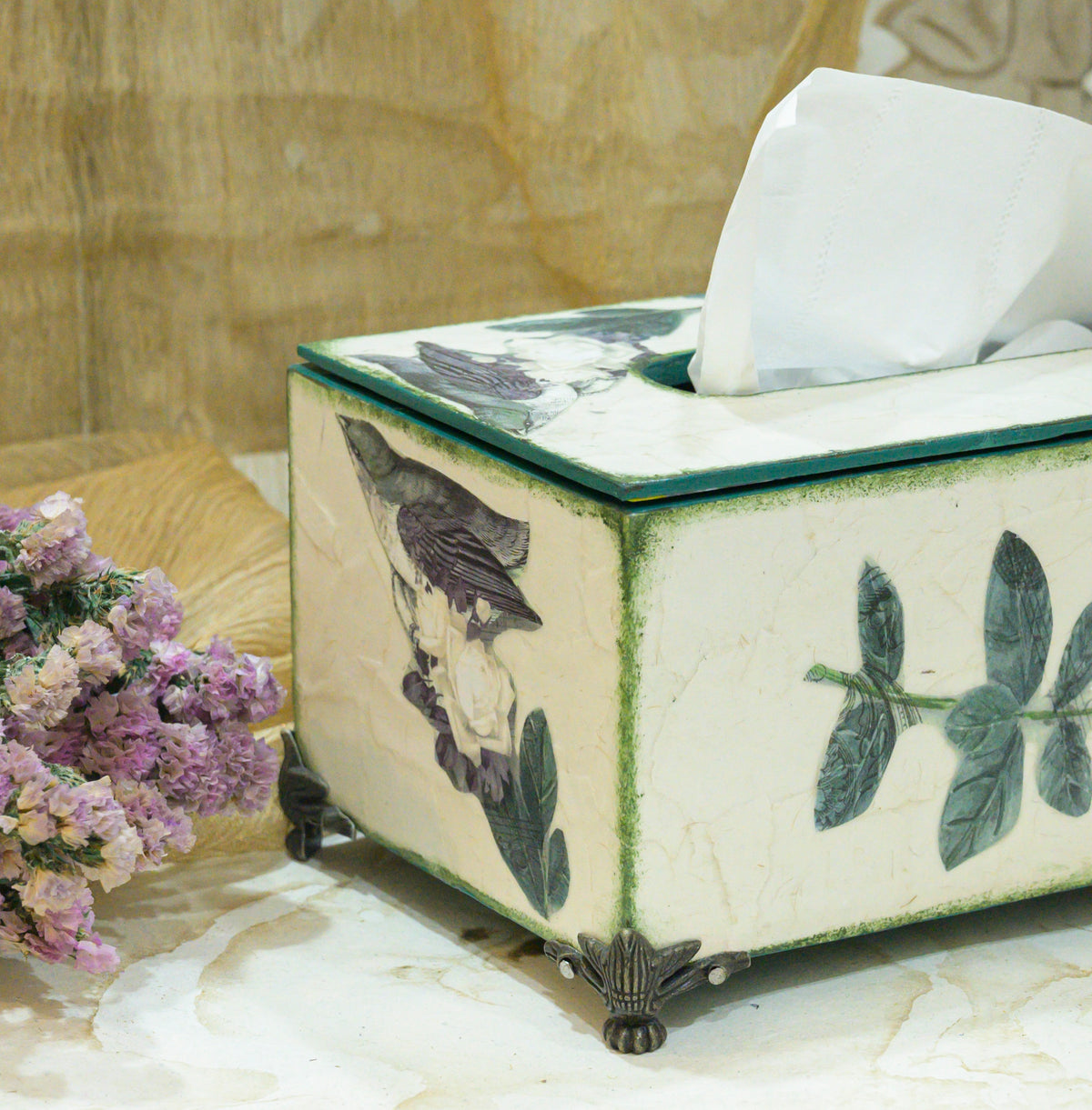 Close-up of off-white and green botanical tissue holder with tissues and brass feet – hoWme