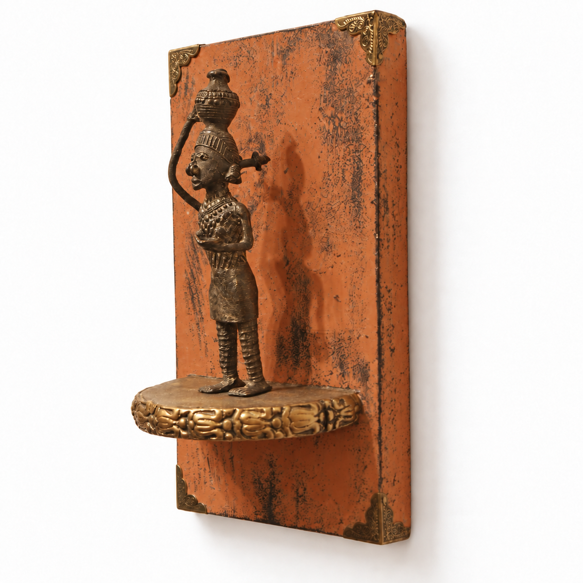 Side view showing the depth of the orange wooden wall shelf and brass figurine – hoWme